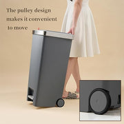 Gray trash bin with wheels and text on a beige background