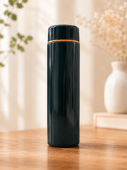 Black thermos bottle on a wooden surface with a blurred background