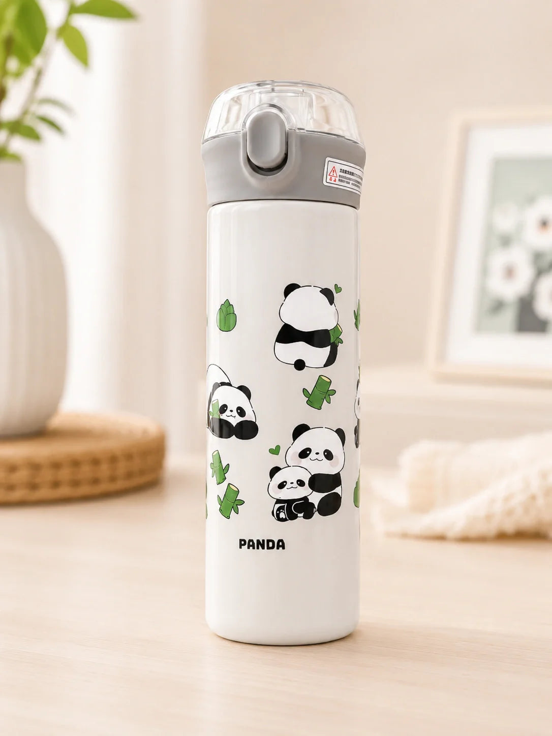 White water bottle with panda designs on a light surface
