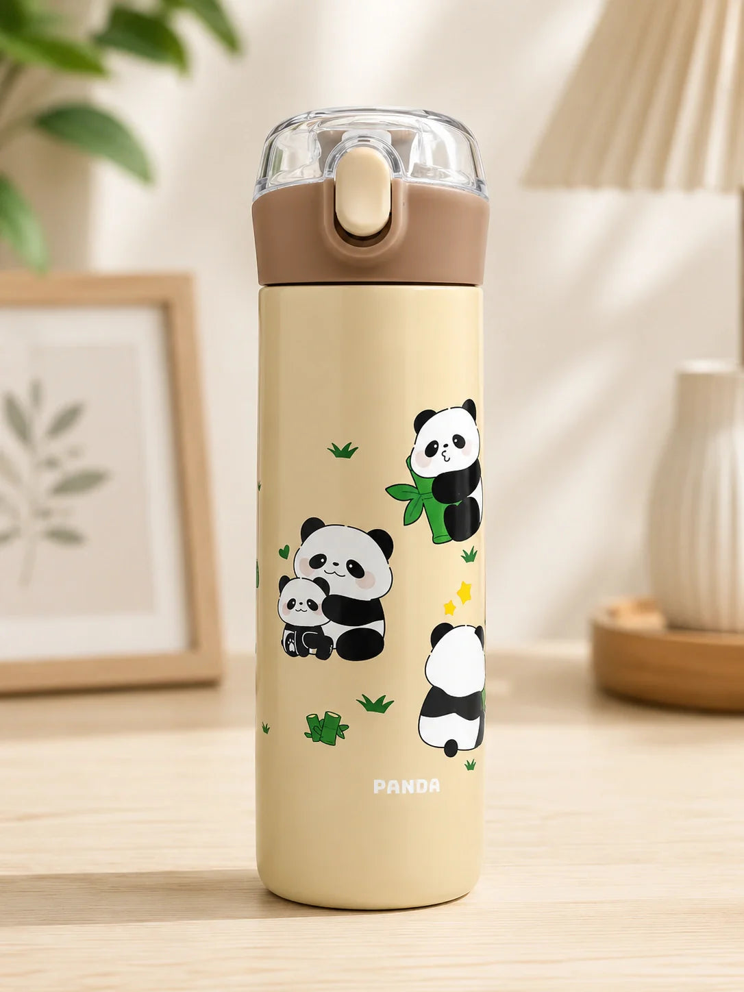 Beige water bottle with panda designs on a wooden surface