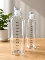 Two clear water bottles with time markings on a wooden surface.