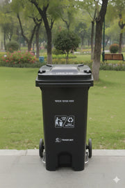Black trash bin with recycling symbols in a park setting
